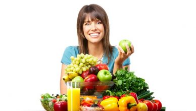 Young smiling woman  with fruits and vegetables. Over white background