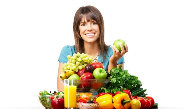 Young smiling woman  with fruits and vegetables. Over white background